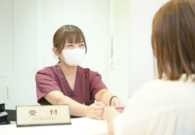 笑顔で対応する受付の女性