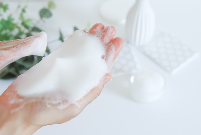 石鹸を泡立てる女性の手元