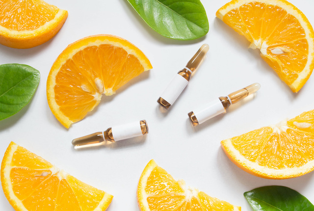ビタミンCのアンプルとスライスされたオレンジ