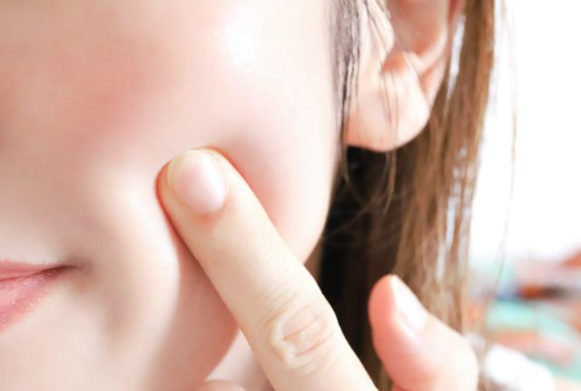 肌のハリを確かめる女性