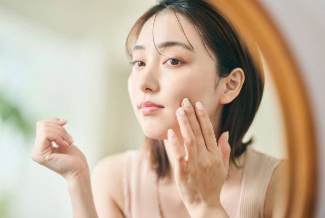 鏡で肌の状態を確認する女性